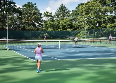 Oilaviy sport mashg'ulotlari, ota-onalar bolalari bilan ochiq kortda tennis o'ynamoqda, sog'lom turmush tarzi